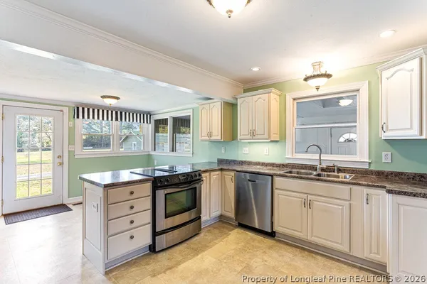 a kitchen with granite countertop white cabinets and stainless steel appliances