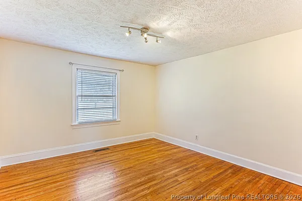 a view of an empty room with wooden floor