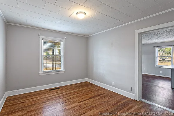 a view of an empty room with wooden floor