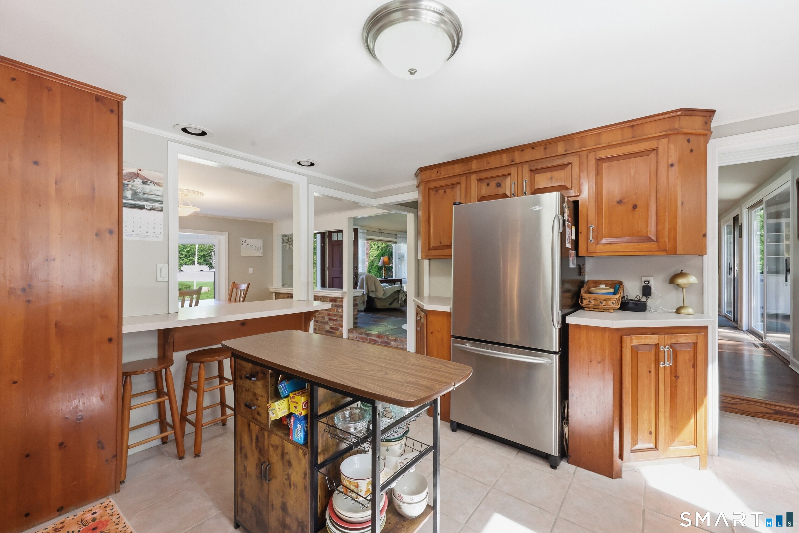 174 Canton Road Granby, CT 06035 - Photo 7 of 35 a kitchen with stainless steel appliances granite countertop a refrigerator a stove a sink a dining table and chairs with wooden floor