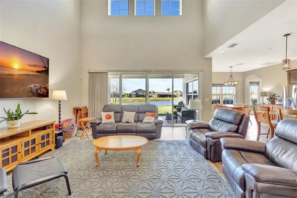 a dining hall with stainless steel appliances granite countertop a kitchen island a table and chairs