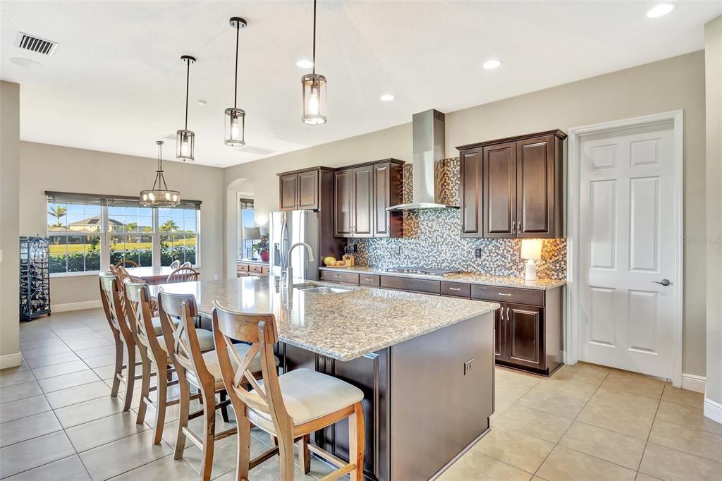 6324 Brevada Lane Apollo Beach, FL 33572 - Photo 14 of 45 a dining hall with stainless steel appliances granite countertop a kitchen island a table and chairs