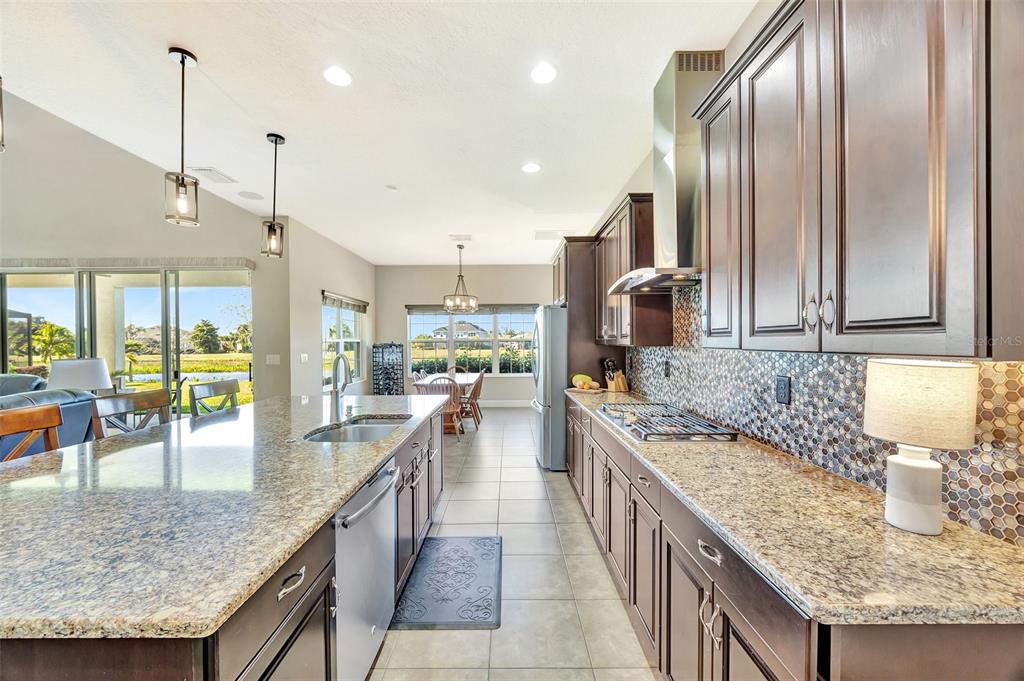 6324 Brevada Lane Apollo Beach, FL 33572 - Photo 15 of 45 a kitchen with stainless steel appliances granite countertop a sink a counter top space appliances and a center island