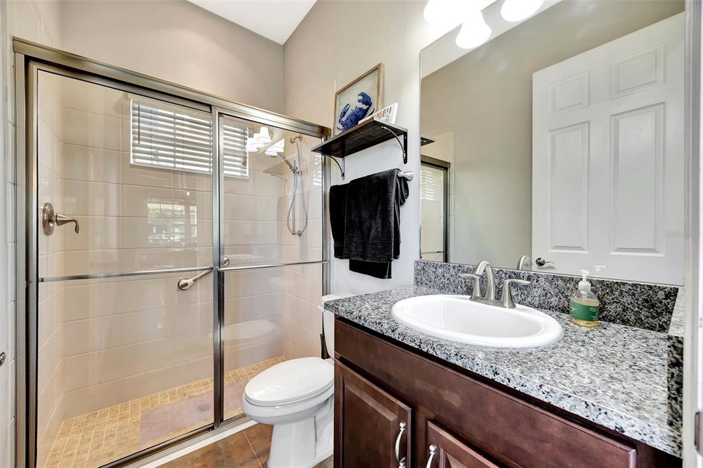 6324 Brevada Lane Apollo Beach, FL 33572 - Photo 21 of 45 a bathroom with a granite countertop sink toilet and shower