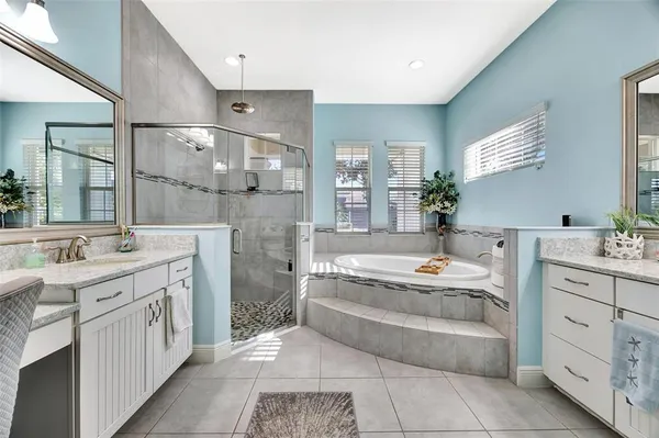 a bathroom with a tub sink and mirror