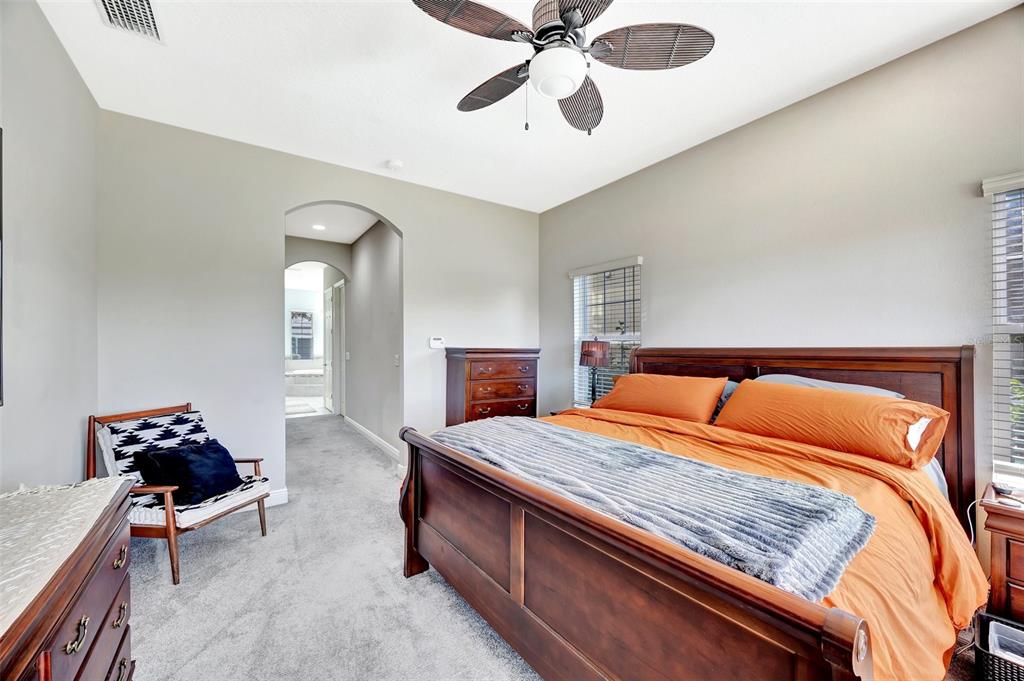 6324 Brevada Lane Apollo Beach, FL 33572 - Photo 25 of 45 a bedroom with a bed and a chandelier