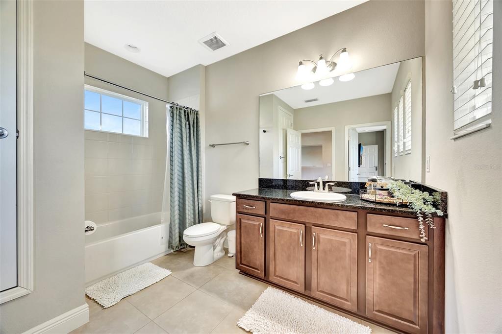 6324 Brevada Lane Apollo Beach, FL 33572 - Photo 36 of 45 a spacious bathroom with a granite countertop sink a toilet a mirror and shower
