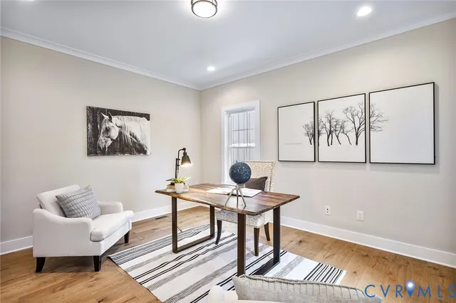 a workspace with furniture and paintings on the wall