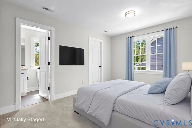 a bedroom with a bed tv and a window