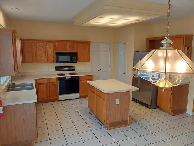 a kitchen with a stove top oven cabinets and a refrigerator