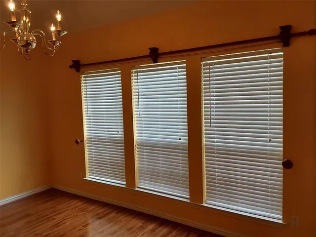 a view of a room with wooden floor and a window