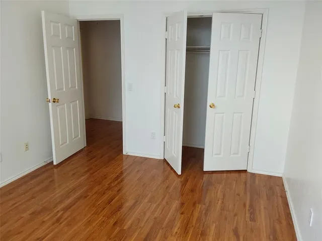 an empty room with wooden floor and closet