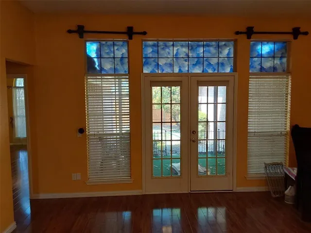 a view of a room that has wooden floor and a window