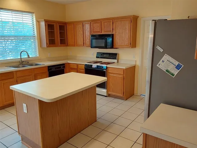 a kitchen with stainless steel appliances a stove refrigerator sink and microwave
