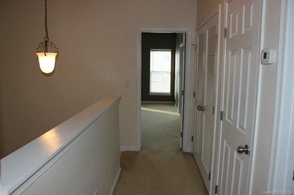 409 Armour Street Davidson, NC 28036 - Photo 11 of 24 a view of a hallway with wooden floor and a chandelier