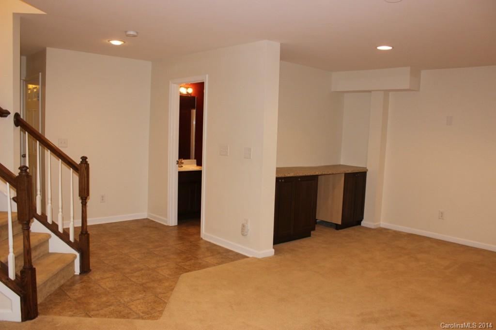 409 Armour Street Davidson, NC 28036 - Photo 18 of 24 a view of an empty room with wooden floor and stairs