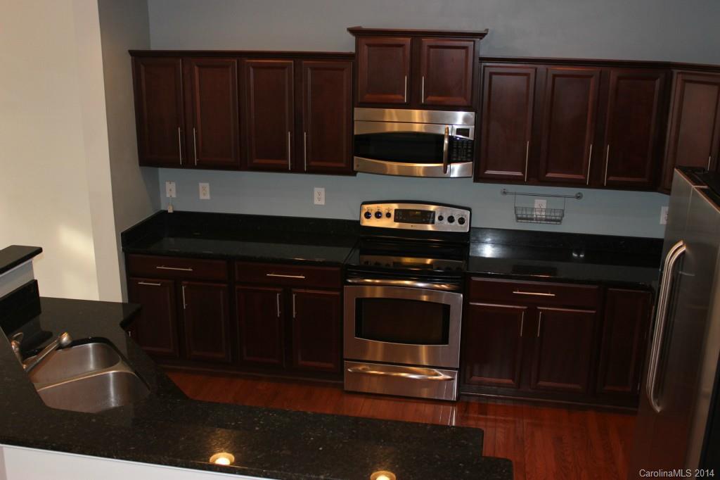 409 Armour Street Davidson, NC 28036 - Photo 5 of 24 a kitchen with granite countertop stainless steel appliances a stove a microwave and sink