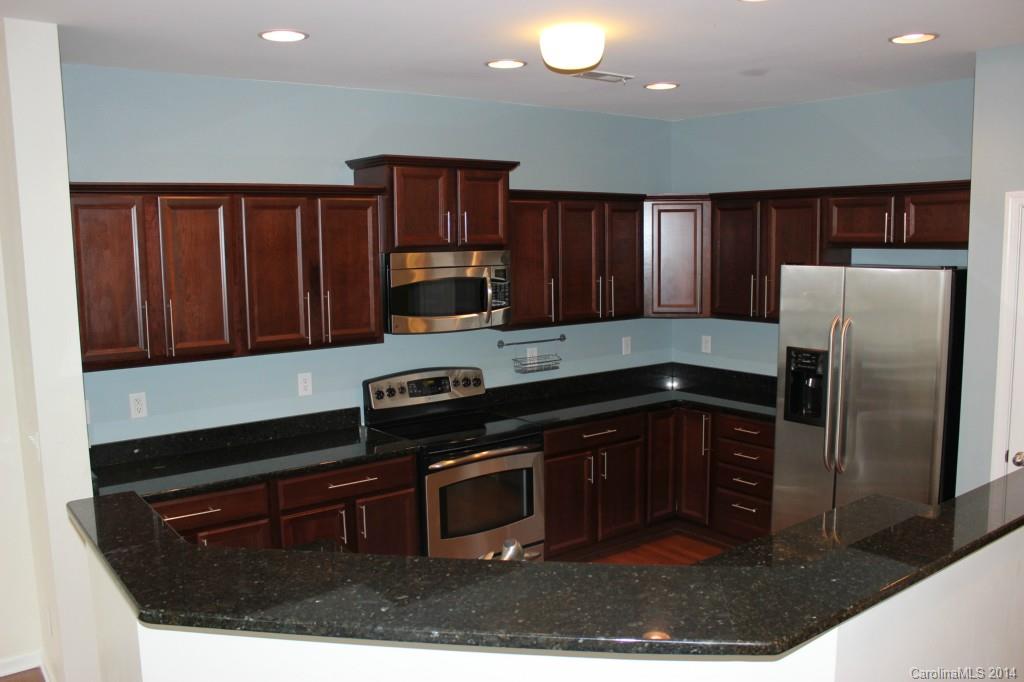 409 Armour Street Davidson, NC 28036 - Photo 6 of 24 a kitchen with granite countertop a refrigerator stove and microwave