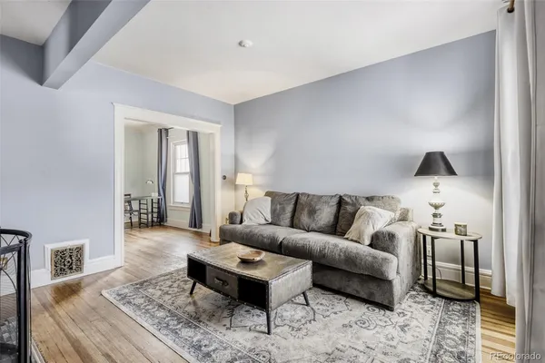 a living room with furniture and wooden floor