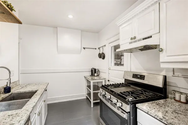 a kitchen with granite countertop a stove and a sink