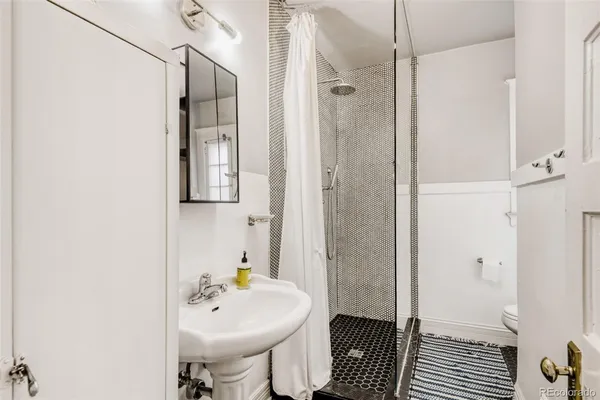a bathroom with a sink a toilet and shower