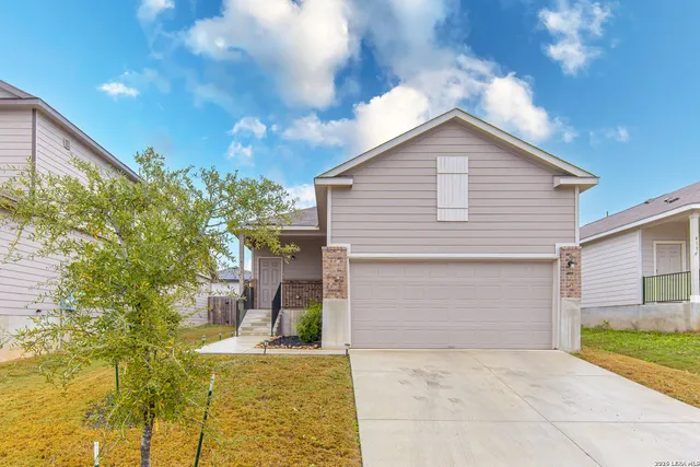 a view of a house with a yard and garage