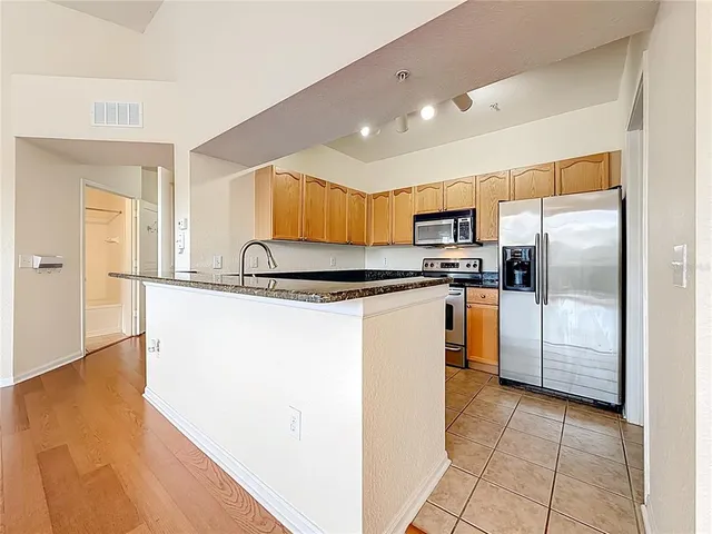 an empty room with wooden floor cabinet and windows