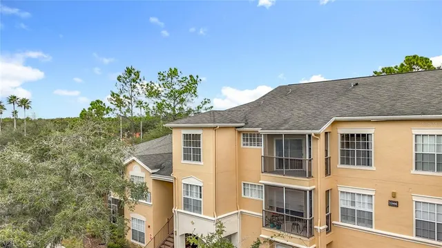 a view of an empty room with chandelier and wooden floor