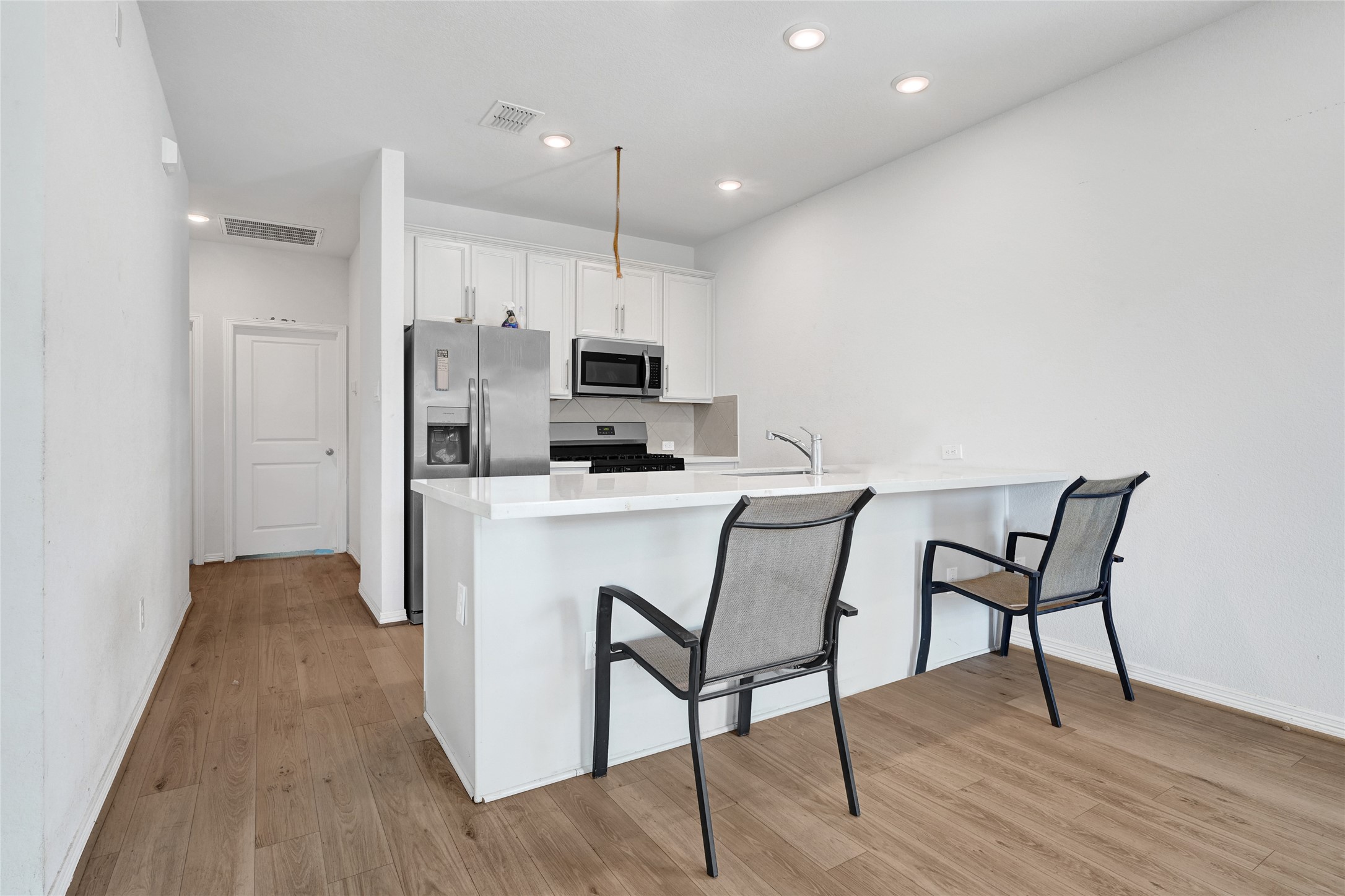 6320 Paris Street Houston, TX 77021 - Photo 3 of 16 a kitchen with kitchen island a dining table chairs refrigerator and microwave