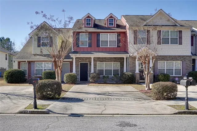 a front view of a house with yard and parking