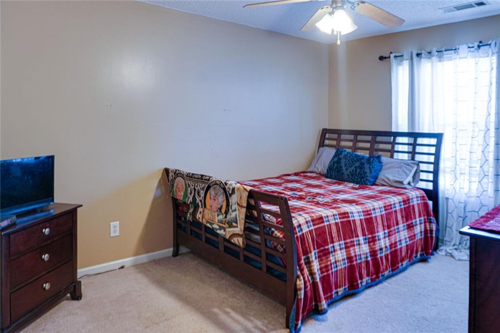 7071 Galloway Point Riverdale, GA 30296 - Photo 11 of 22 a bedroom with a bed and a flat tv screen on dresser