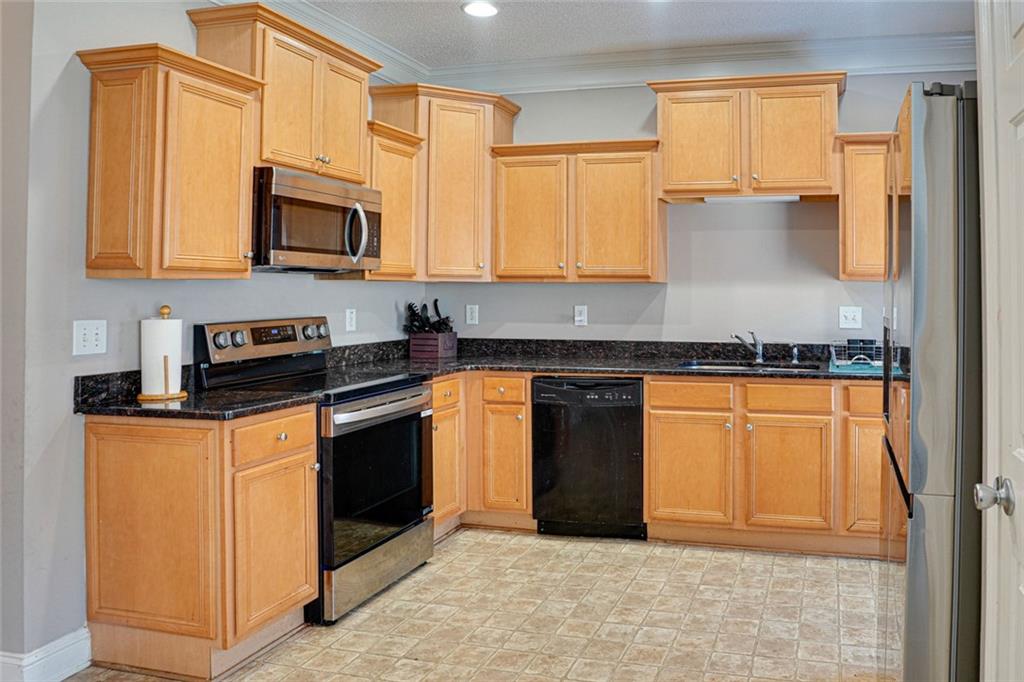 7071 Galloway Point Riverdale, GA 30296 - Photo 7 of 22 a kitchen with stainless steel appliances granite countertop a stove a sink and a microwave