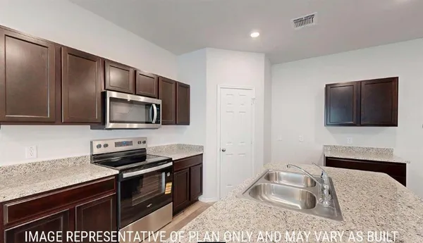 a kitchen with a stove microwave and sink
