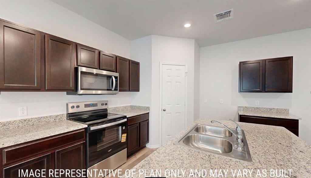 10225 Altair Drive Waco, TX 76708 - Photo 3 of 13 a kitchen with a stove microwave and sink