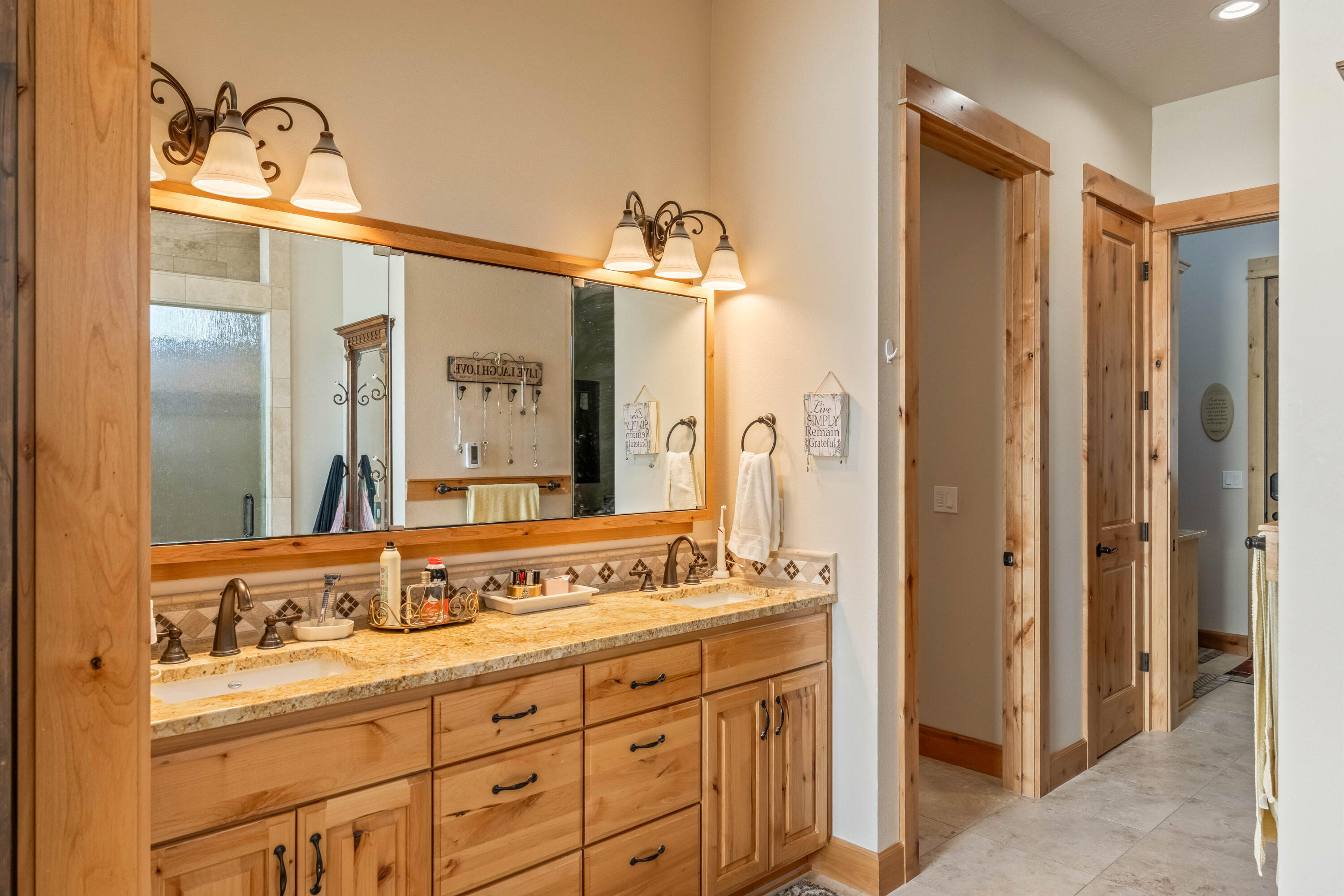 70030 Northwest Hunt Road Sisters, OR 97759 - Photo 14 of 55 a bathroom with a double vanity sink and mirror with shower