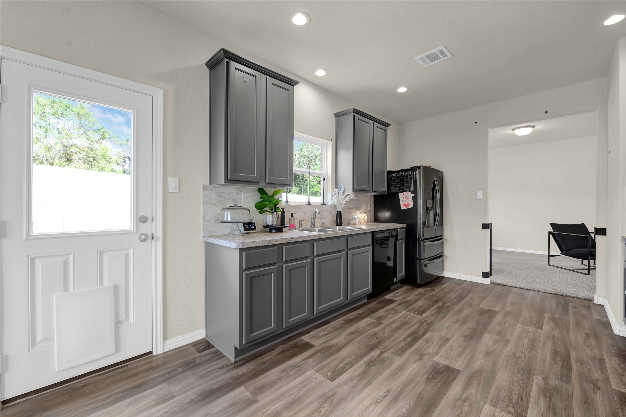 17703 Lion Heart Road Conroe, TX 77306 - Photo 10 of 26 a kitchen with stainless steel appliances granite countertop a refrigerator a sink dishwasher a stove and a dining table with wooden floor