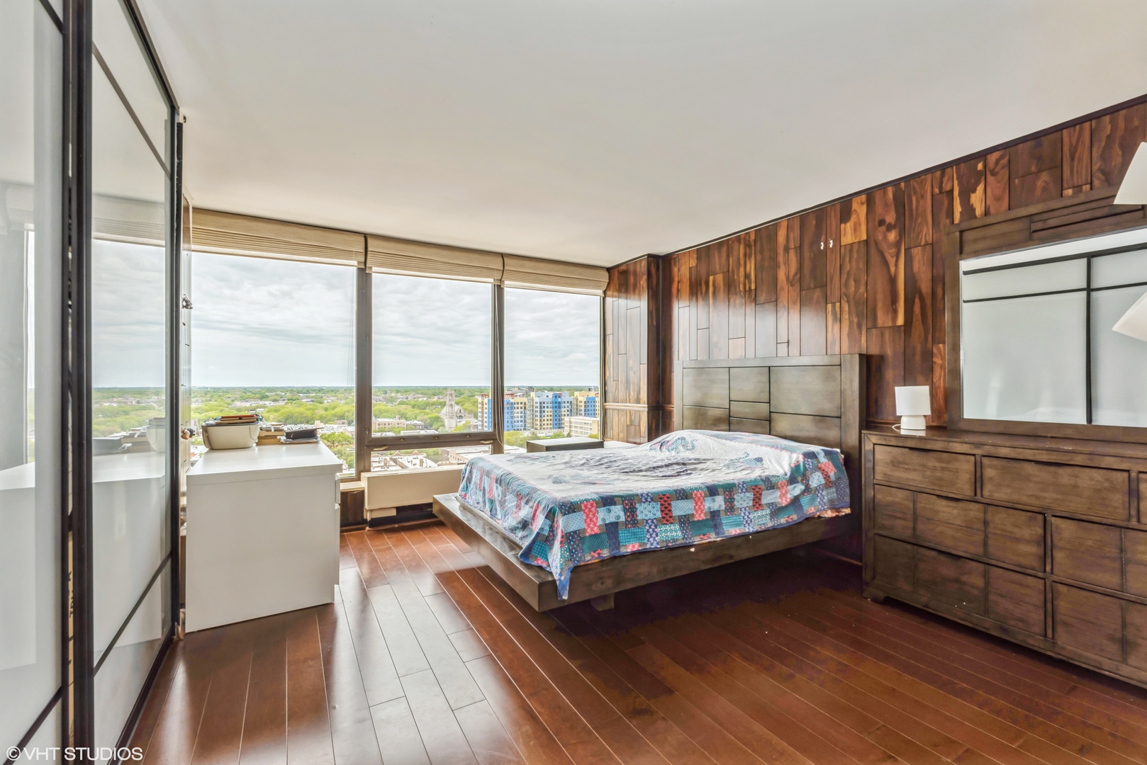 5445 North Sheridan Road, Unit 1815 Chicago, IL 60640 - Photo 12 of 14 a large bedroom with a bed and large window with wooden floor