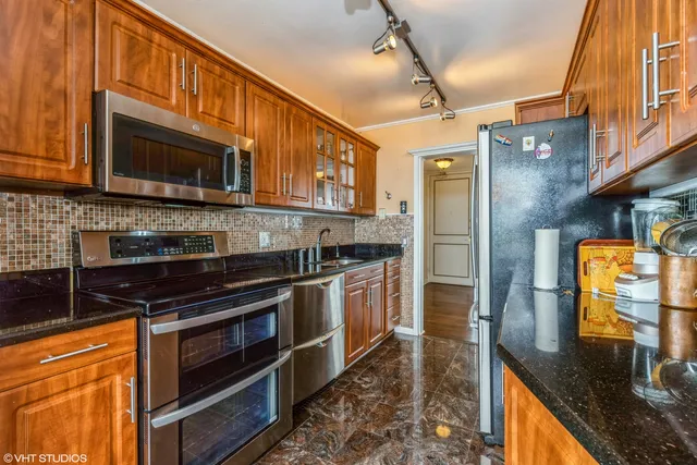 a kitchen with stainless steel appliances granite countertop a stove a sink and a microwave