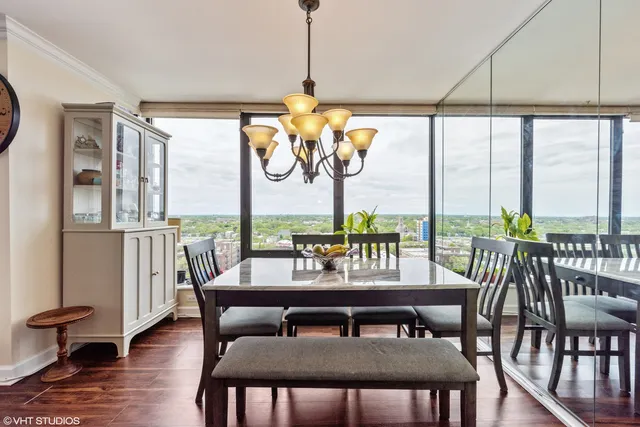 a dining room with furniture a chandelier and wooden floor
