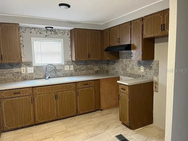 a kitchen with stainless steel appliances granite countertop a sink stove and cabinets