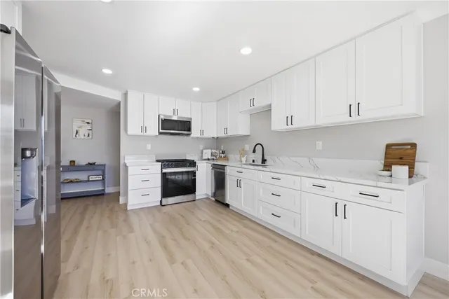 a kitchen with stainless steel appliances a refrigerator sink and cabinets