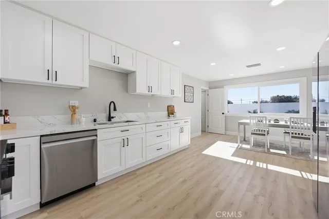 a kitchen with white cabinets and sink