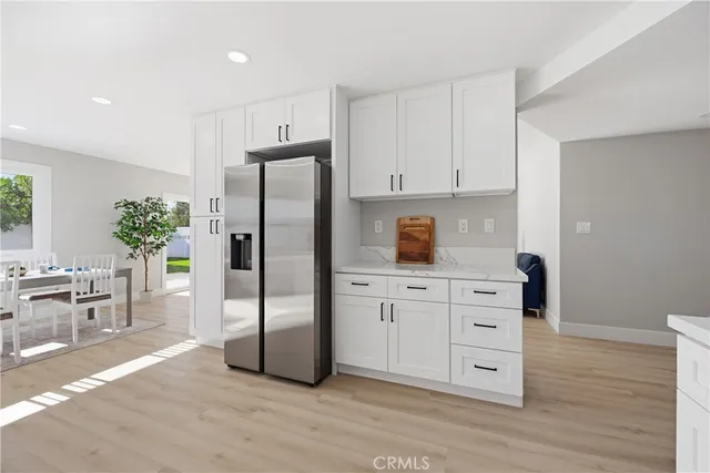 a kitchen with white cabinets and stainless steel appliances