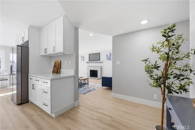 a view of kitchen with stainless steel appliances cabinets potted plant and wooden floor