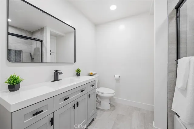 a bathroom with a sink a toilet and mirror