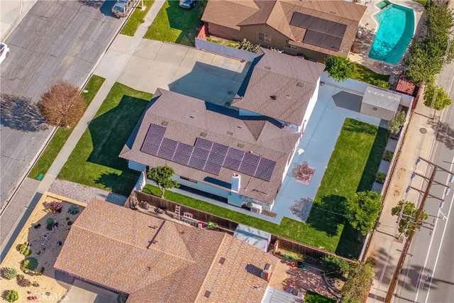 an aerial view of a house with a yard pool outdoor seating and outdoor kitchen