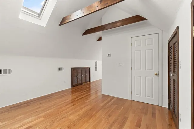 a view of an empty room with wooden floor