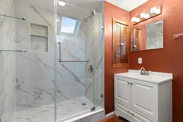 a bathroom with a sink mirror and shower