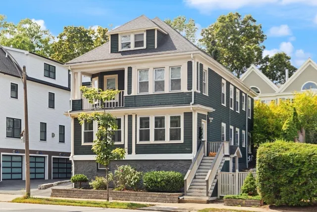 a front view of a building with a garden and plants