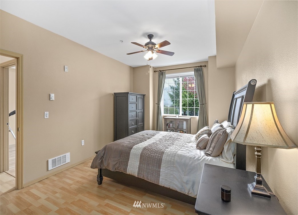 3012 Southeast 8th Place, Unit 1117 Renton, WA 98058 - Photo 15 of 40 a bedroom with a bed and a chandelier